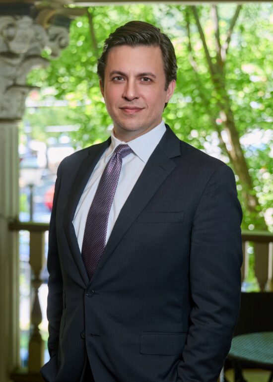 Stephen A Younblood standing with a suit and tie in a park setting.