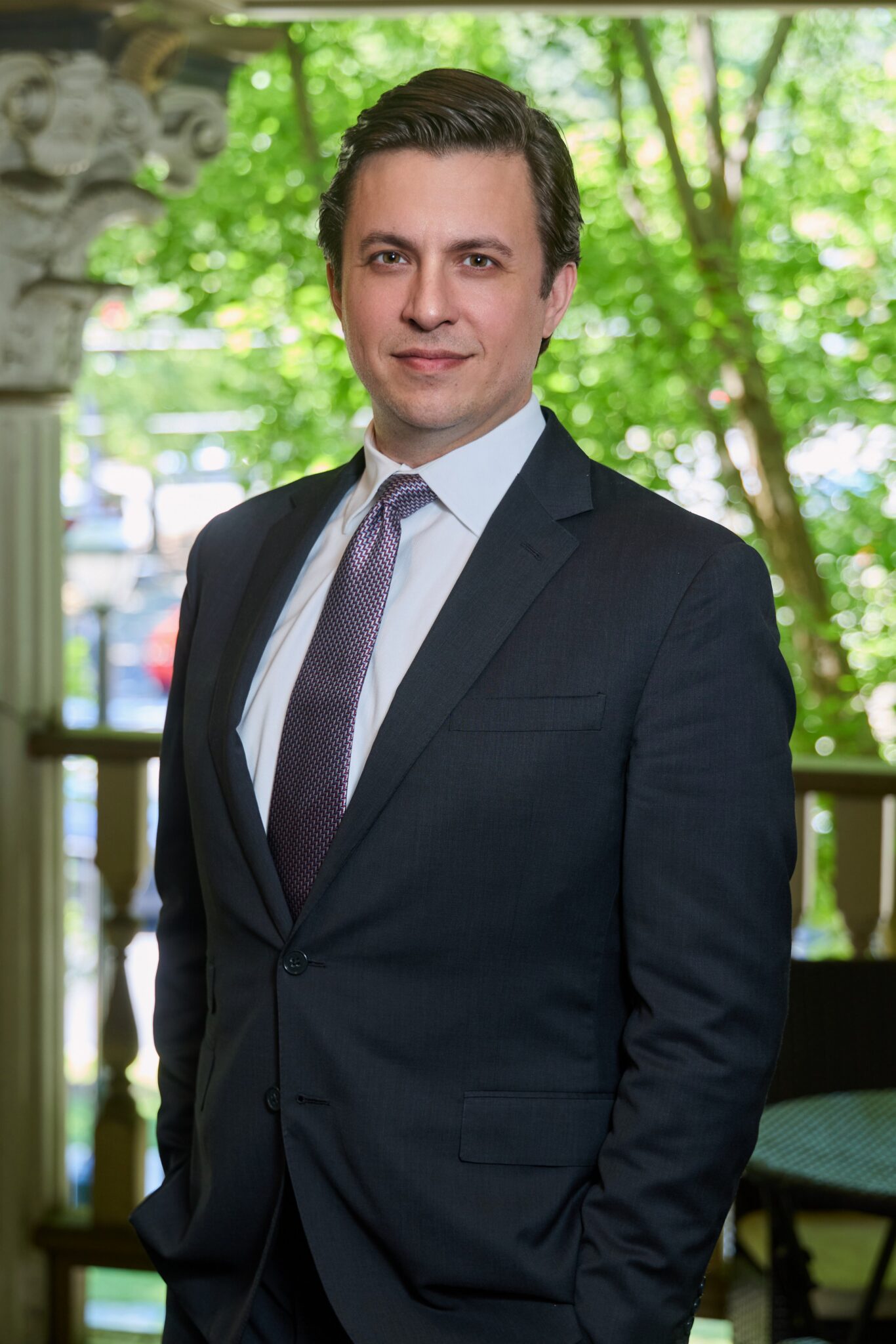 Stephen A Younblood standing with a suit and tie in a park setting.